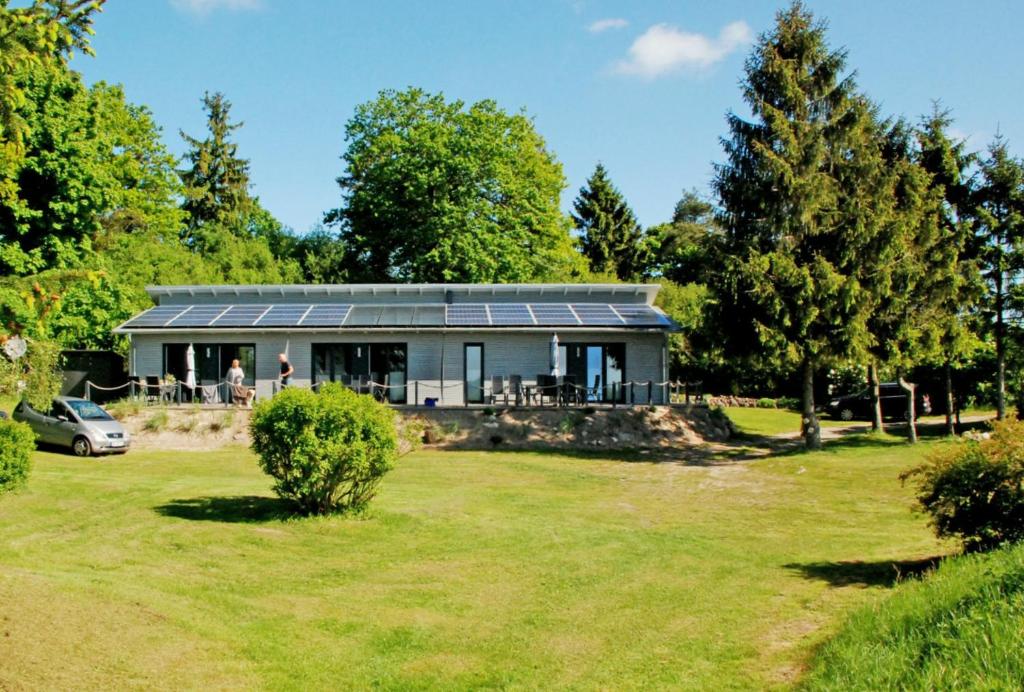 a house with solar panels on top of a yard at naturnah, mit Terrasse, Garten und Meerblick - Ferienwohnung auf dem Teschenberg in Middelhagen