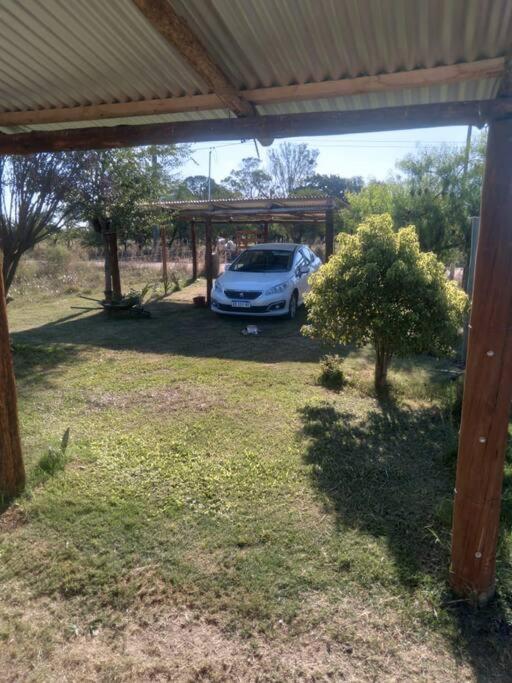 une voiture garée sous un abri dans une cour dans l'établissement Casa en la Colonia - PetFriendly, à Concepción del Uruguay