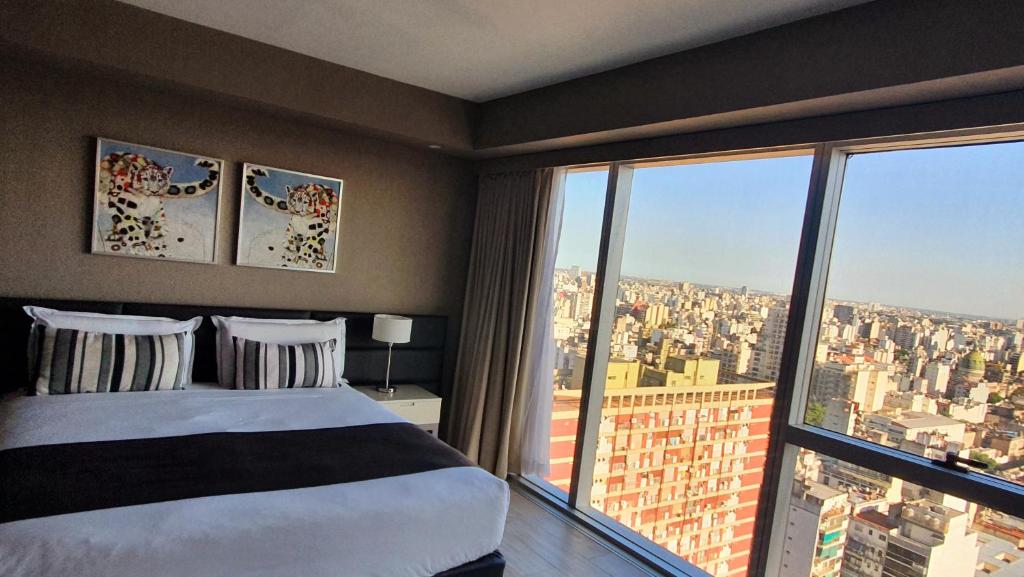 GrandView Hotel Buenos Aires في بوينس آيرس: غرفة نوم بسرير ونافذة كبيرة