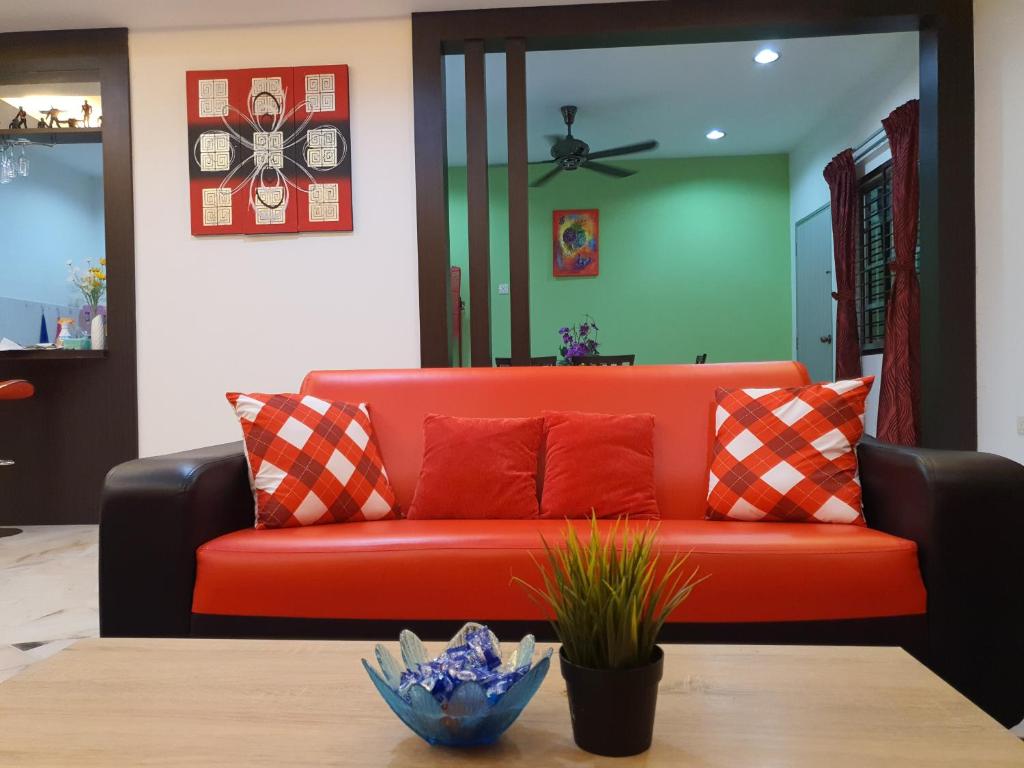a red couch in a living room with a table at Homey Homestay in Tanjong Sepat