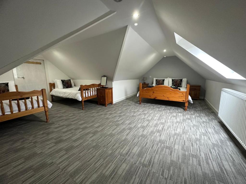 a attic room with two beds and two beds sidx sidx sidx sidx sidx at 3 Dialknowe Holiday Cottage - Wanlockhead in Wanlockhead