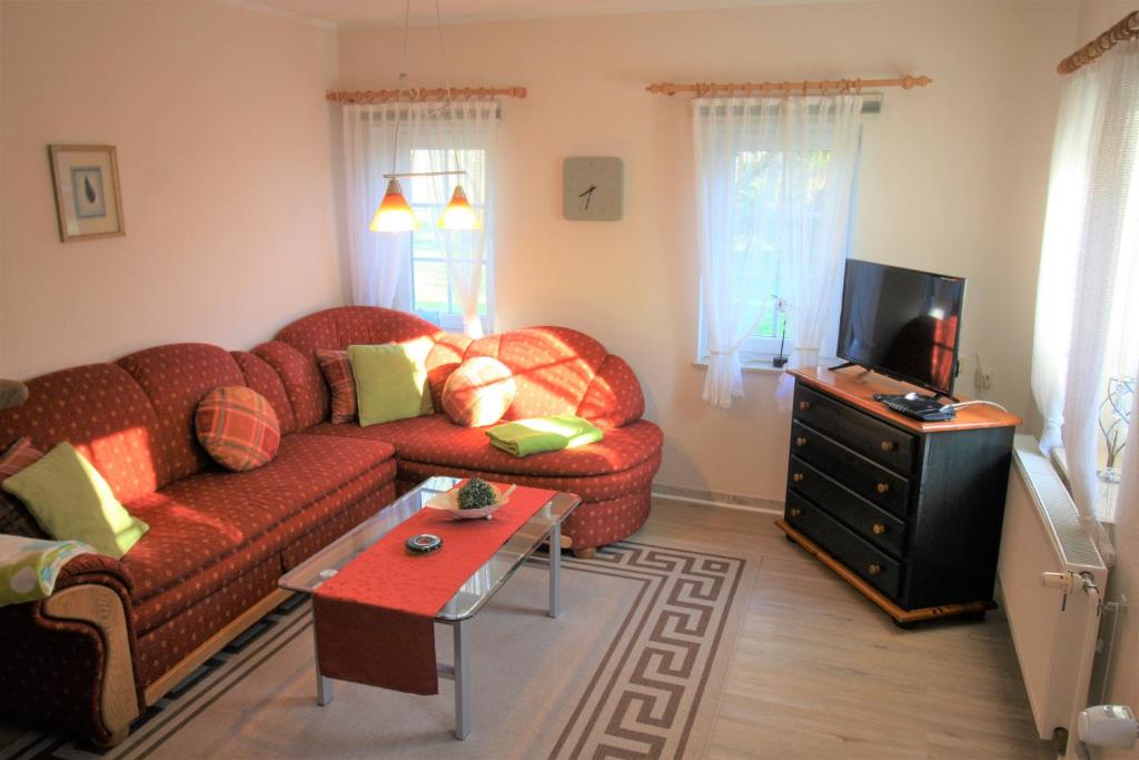 a living room with a couch and a tv at Kleinheide 1 in Berumbur