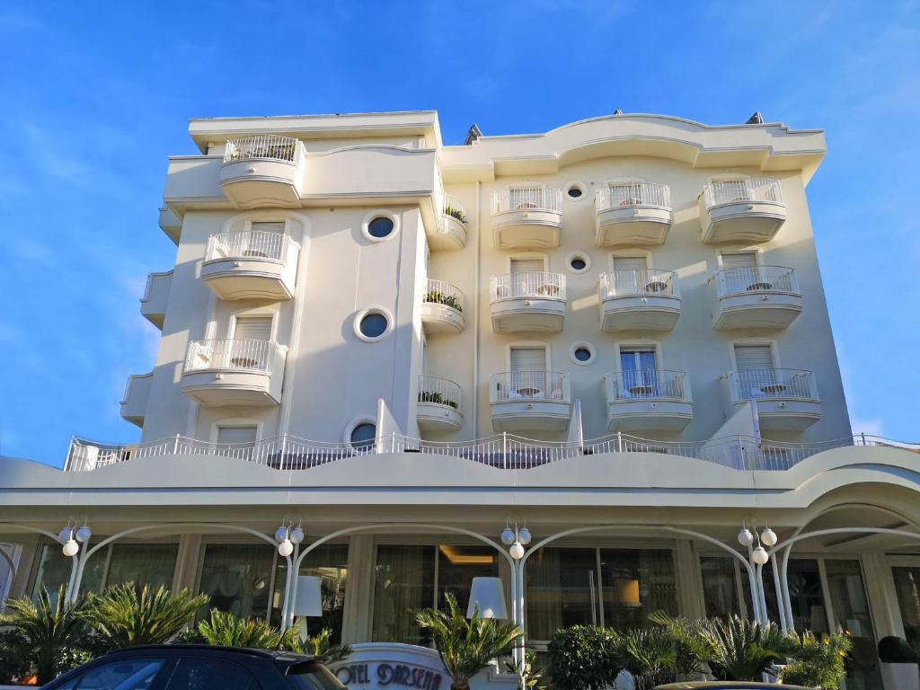 Biały budynek z samochodem zaparkowanym przed nim w obiekcie Hotel Darsena w mieście Riccione