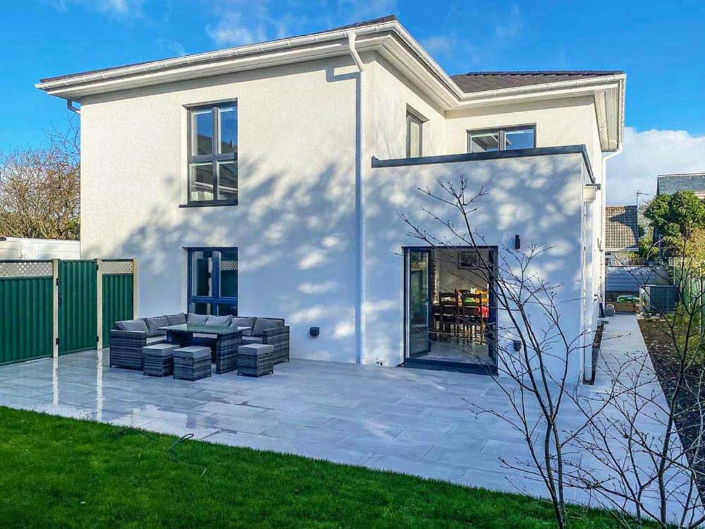 uma casa branca com um pátio em frente em Remarkable 4-Bed House in St Minver Rock em Wadebridge