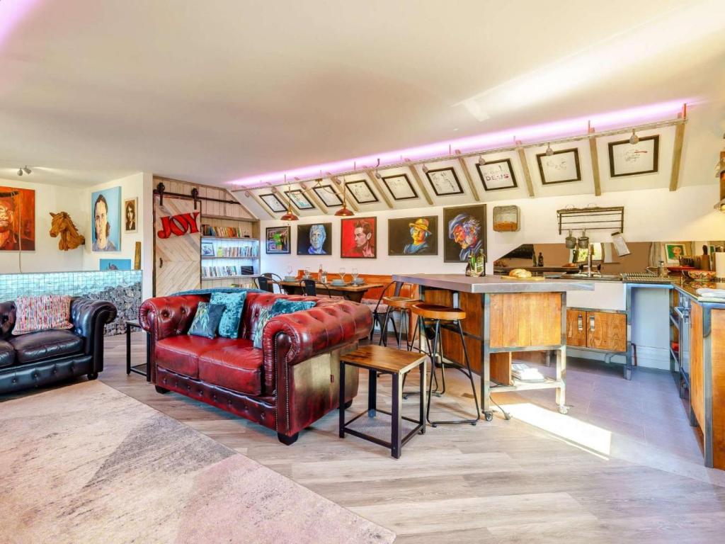 a living room with a red couch and a bar at The Artist Studio in Hest Bank