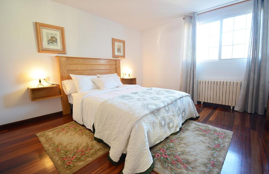 a bedroom with a large bed and a window at Casa con jardín en Vilanova de Arousa in Pontevedra