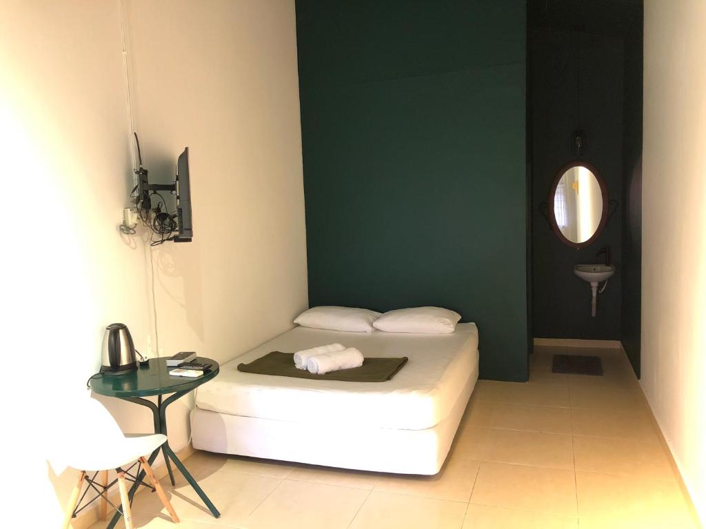 a bedroom with a bed and a table and a mirror at Rumah Tepi Istana in Kuala Terengganu