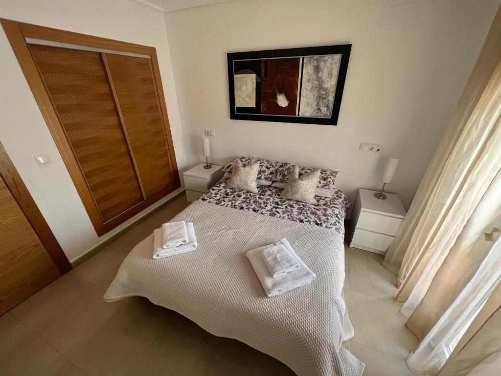 a bedroom with a bed with two towels on it at Apartment in Hacienda Riquelme Golf Resort in Sucina
