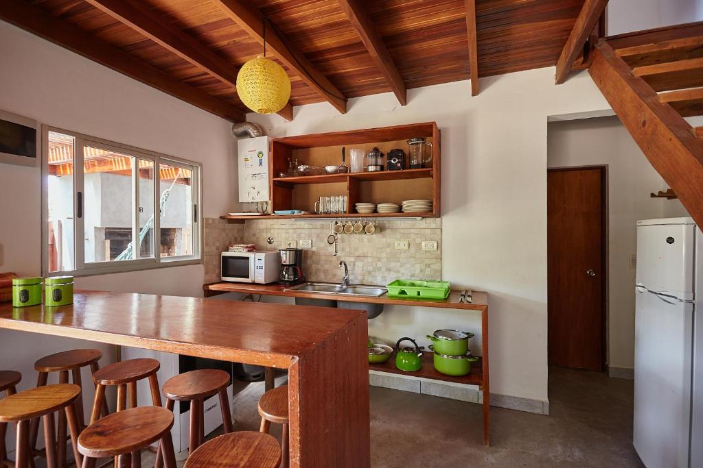 a kitchen with a counter and some wooden stools at Elén in Punta Del Diablo
