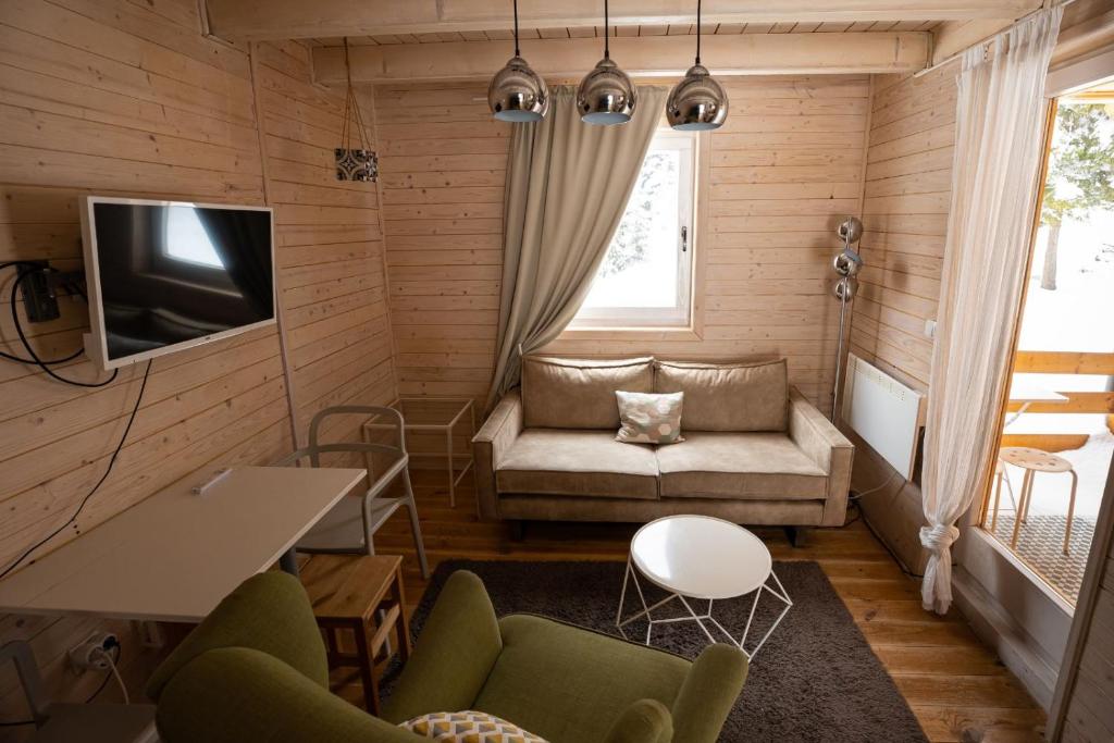 una pequeña sala de estar con sofá y TV en ZlatAir Eco Chalet en Nova Varoš
