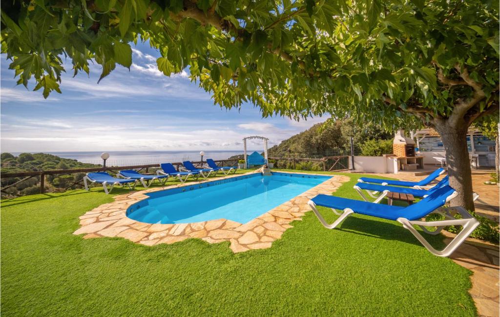 - une piscine avec des chaises et un arbre dans l'établissement Lovely Home In Malgrat De Mar With Swimming Pool, à Malgrat de Mar