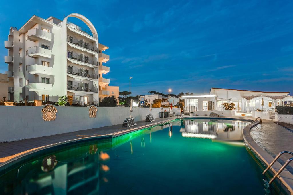 a swimming pool in front of a building at Hotel Cavalluccio Marino in Santa Marinella