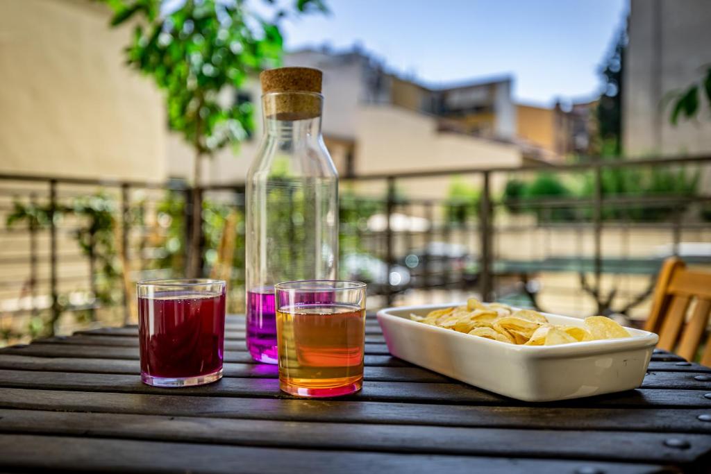 a table with two glasses and a bottle and a bowl of chips at Luxury apt in the heart of city out of ZTL in Florence