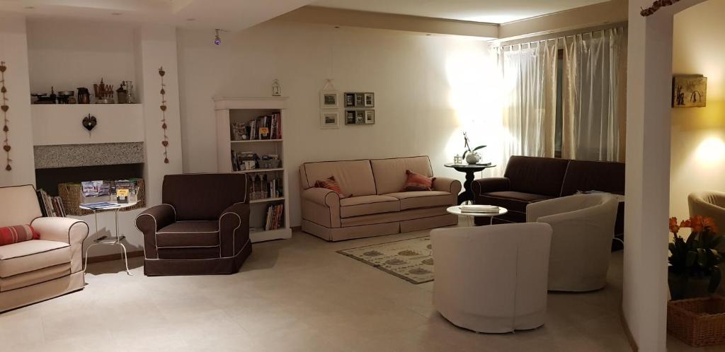un soggiorno con divani, sedie e camino di Garni San Lorenzo a Pinzolo