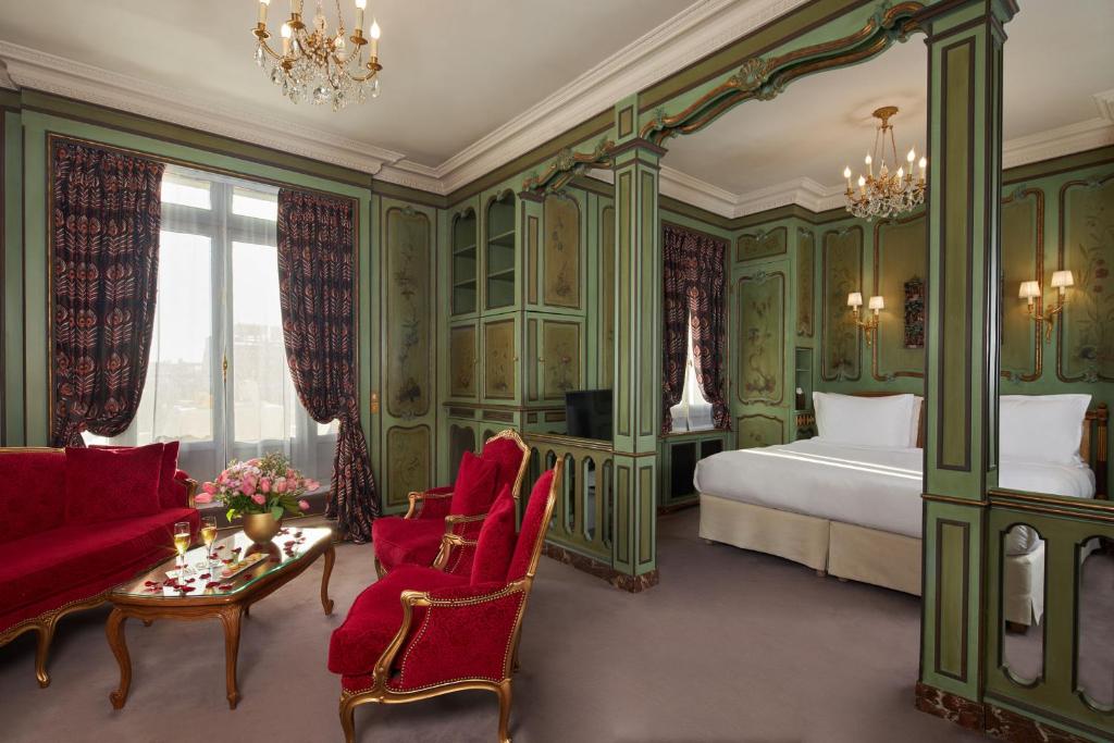 a bedroom with green walls and a bed and a couch at Hôtel Raphael in Paris