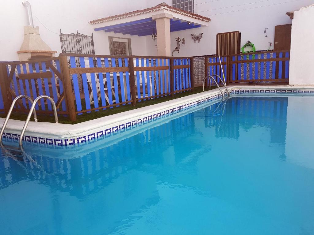 a swimming pool with a wooden deck and a swimming pool at CASA RURAL EL ROCINANTE in Miguel Esteban