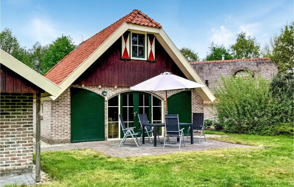 a house with a patio with chairs and an umbrella at Beautiful Home In Ijhorst With House A Panoramic View in IJhorst