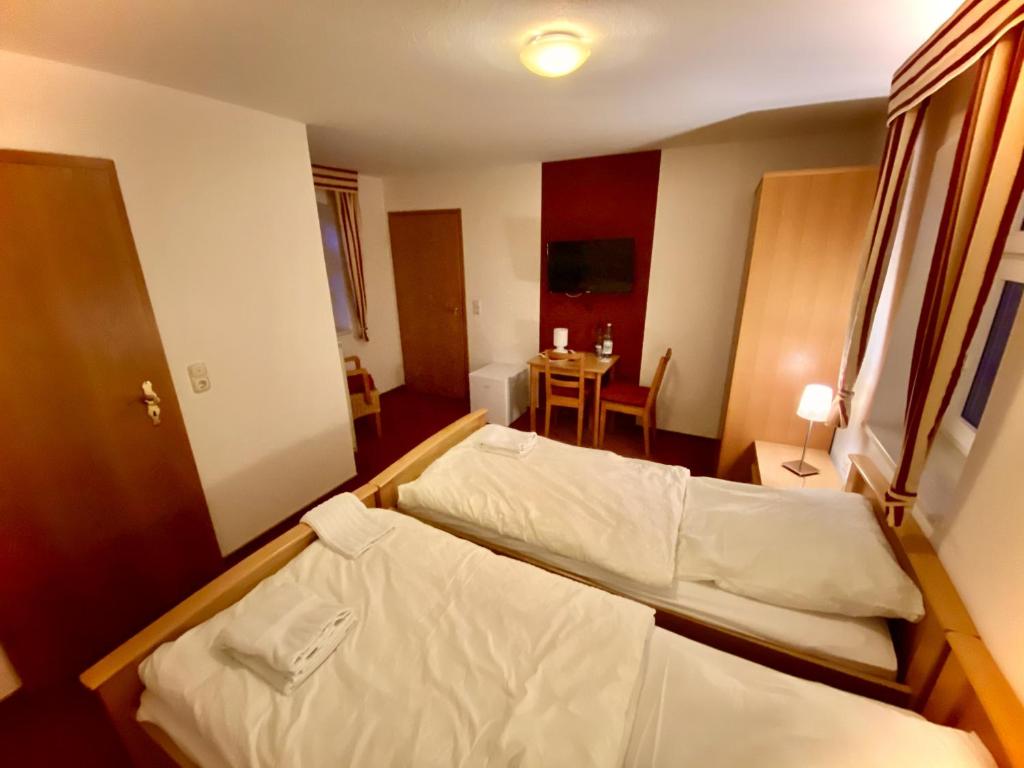 a bedroom with two beds and a table in a room at Privatquartier van Dreuten in Warpe