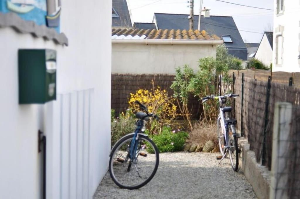 deux vélos garés dans une cour à côté d'une clôture dans l'établissement Maison de vacances La Palue entre plage et centre bourg, au Guilvinec