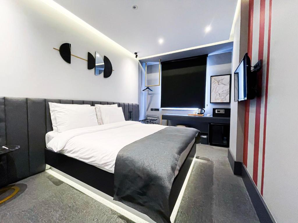 1 dormitorio con 1 cama grande y TV en MELLDAY HOTEL 