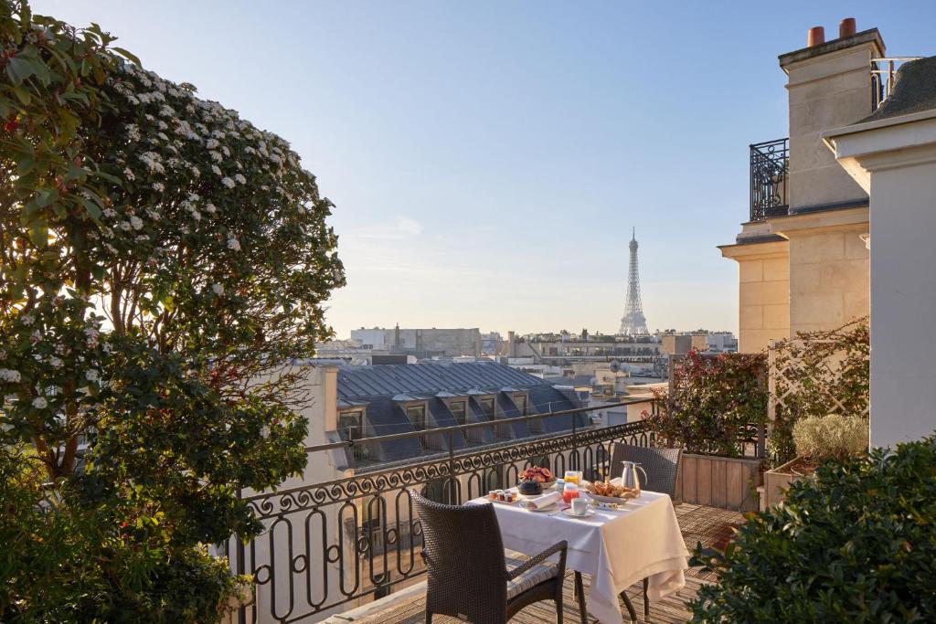 a table on a balcony with a view of the eiffel tower at Hôtel Raphael in Paris