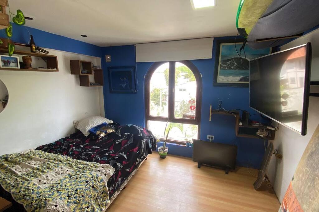 1 dormitorio con 1 cama y TV en Andy House hospedaje en Mar del Plata