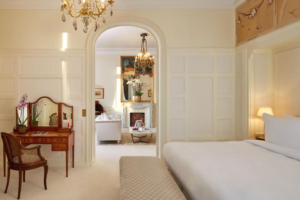 a bedroom with a bed and a desk and a mirror at Hôtel Raphael in Paris