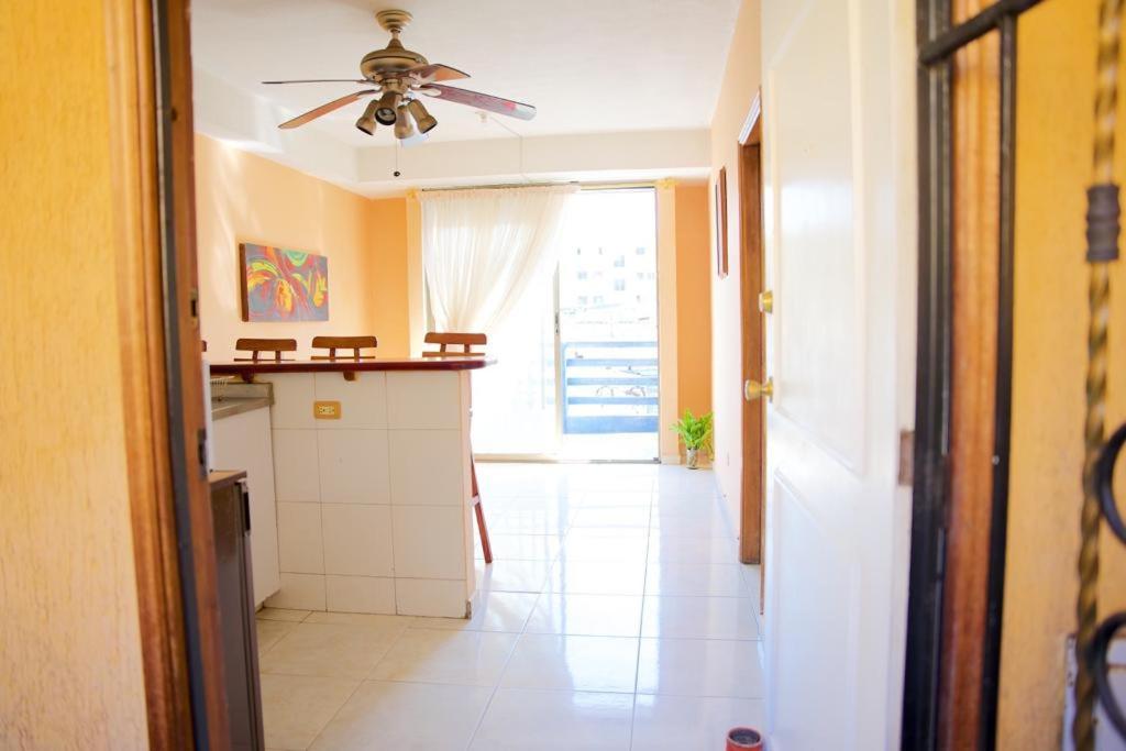 uma cozinha com ventoinha de tecto e piso em azulejo branco em Hermoso y cómodo apartaestudio! em Barranquilla