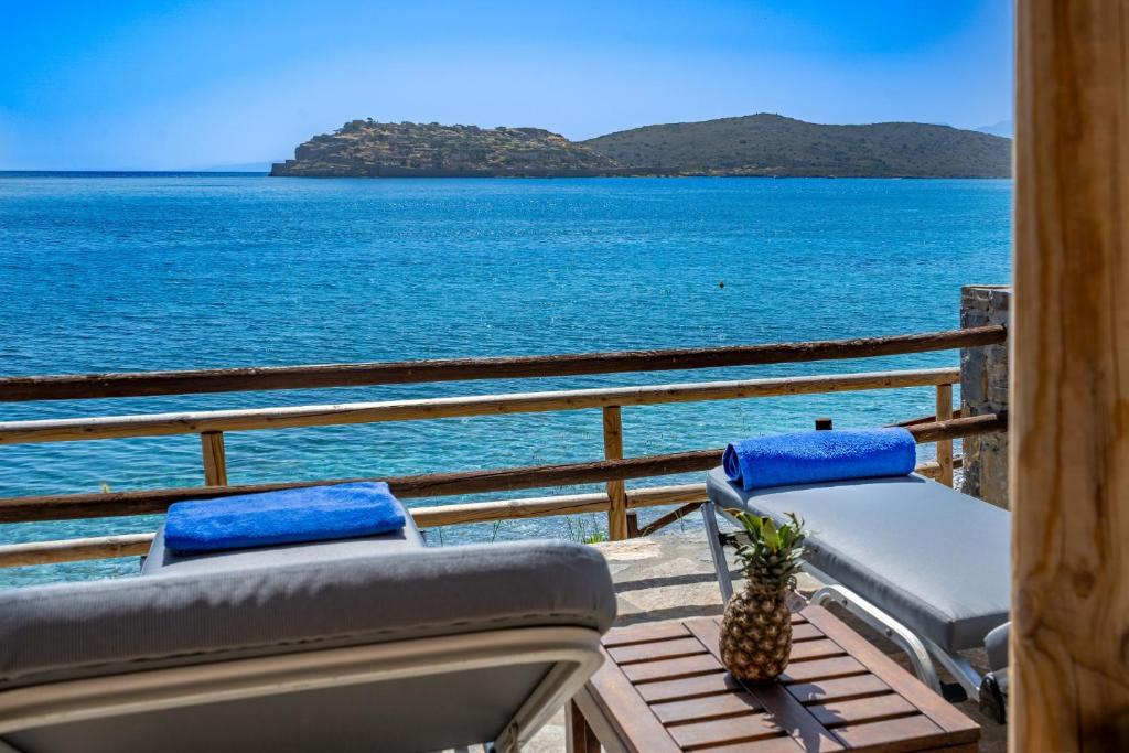 a balcony with chairs and a view of the ocean at Plaka Beach Cottages in Pláka