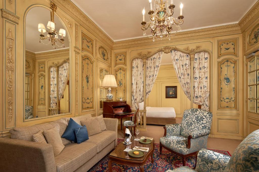 a living room with a couch and a bed at Hôtel Raphael in Paris