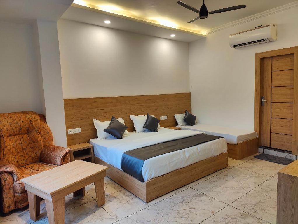 Sonu Guesthouse & Hostel في ريشيكيش: غرفة نوم بسرير وكرسي وأريكة