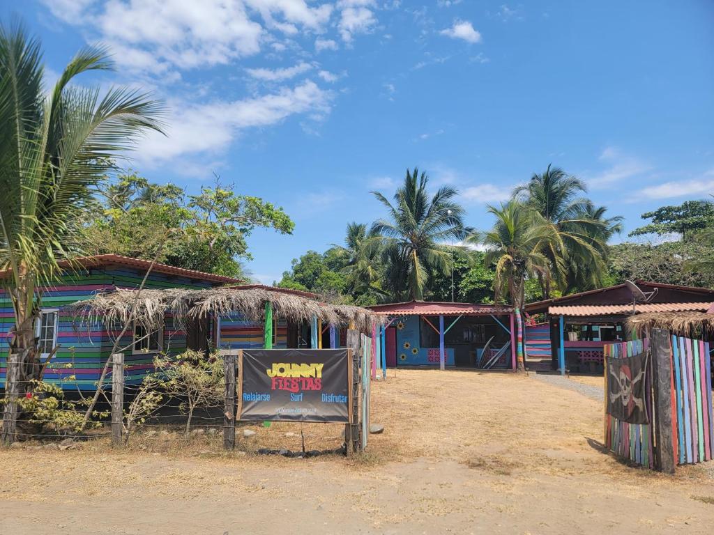 a sign in front of a building with palm trees at Johnny Fiestas in Las Lajas