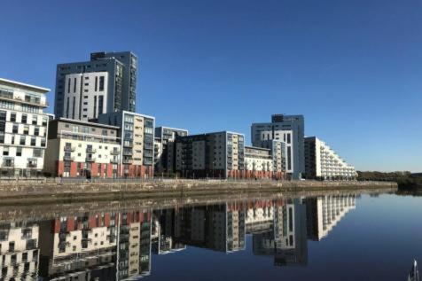 a city with tall buildings next to a body of water at Water view harbour in Glasgow
