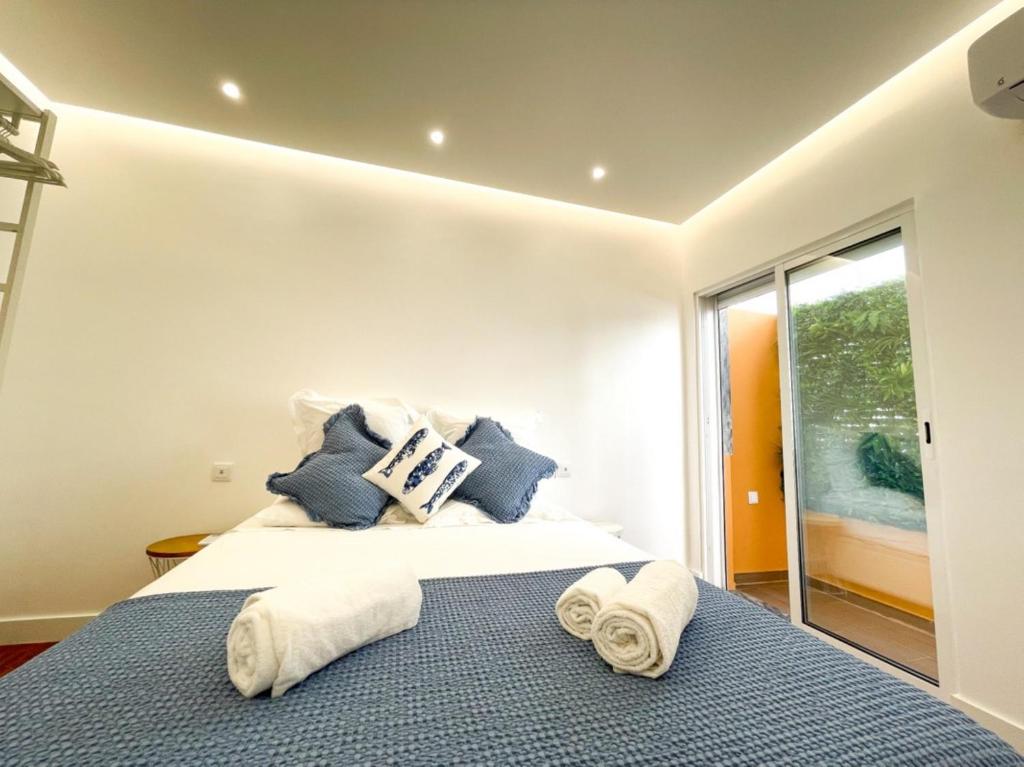 a bedroom with a bed with towels on it at So Sweet Center of Faro Flat in Faro
