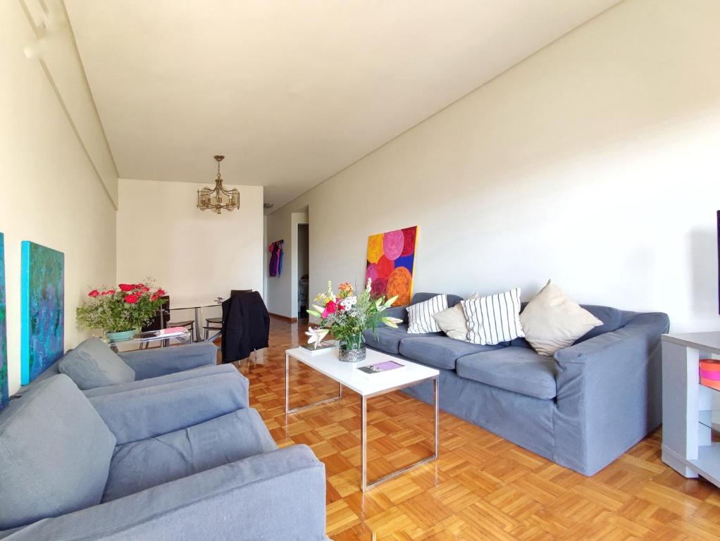 una sala de estar con 2 sofás azules y una mesa. en Alquiler Departamento Temporario de 3 Ambientes, Quintana al 500, Recoleta. en Buenos Aires