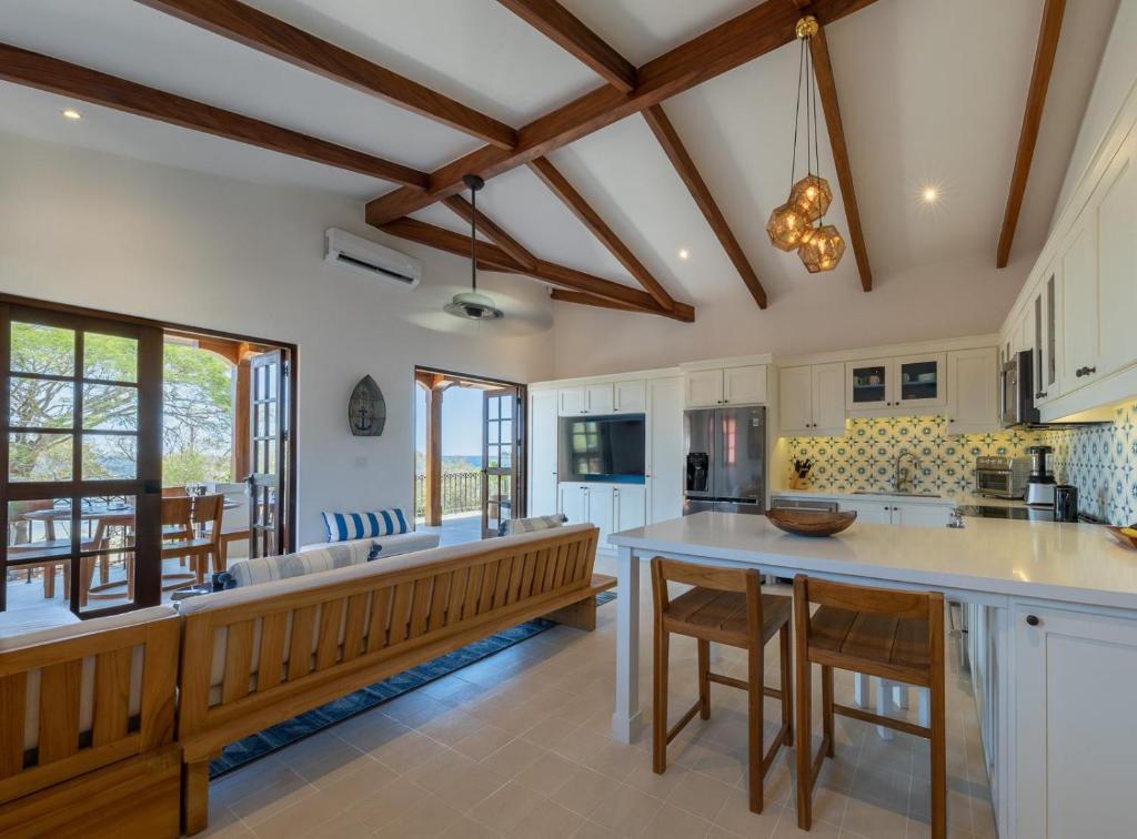 una cocina abierta con armarios blancos y una gran isla. en Plaza Mercado 24 At Las Catalinas, en Playa Danta