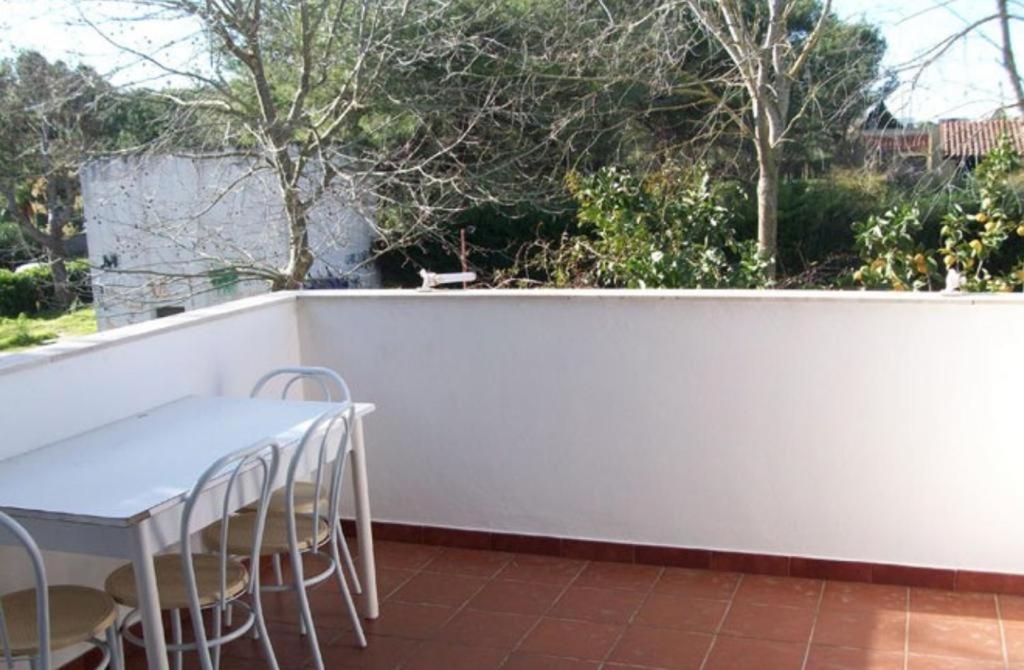 uma cerca branca com uma mesa e cadeiras num pátio em ALLEGRA - Casa Vacanze Torre dell'Orso em Torre dell'Orso