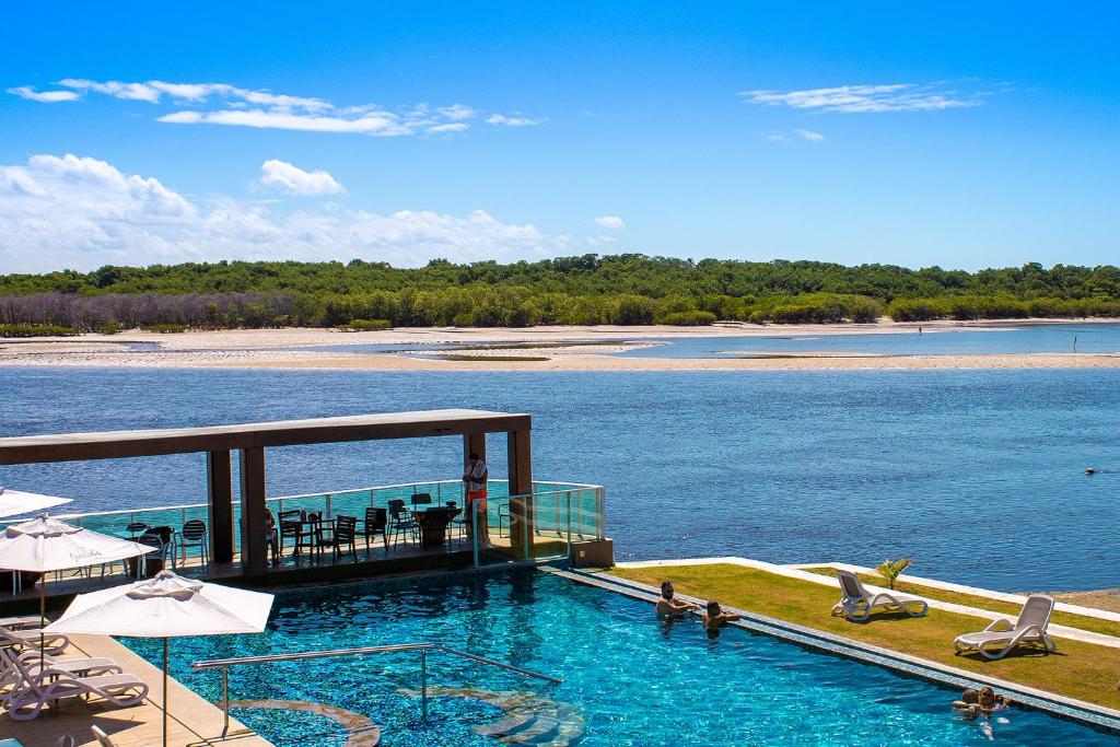 a swimming pool with a view of a body of water at Pousada Jirituba in Barra de Santo Antônio