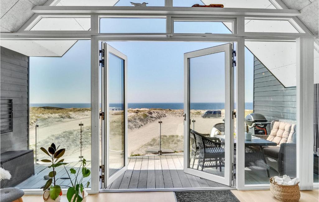 Une porte ouverte s'ouvre sur une terrasse offrant une vue sur la plage. dans l'établissement Awesome Apartment In Thisted With Kitchen, à Thisted