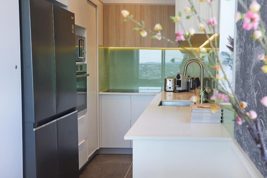 a kitchen with a sink and a refrigerator at Cloud Loft Residence with 180 Degrees Views in Auckland