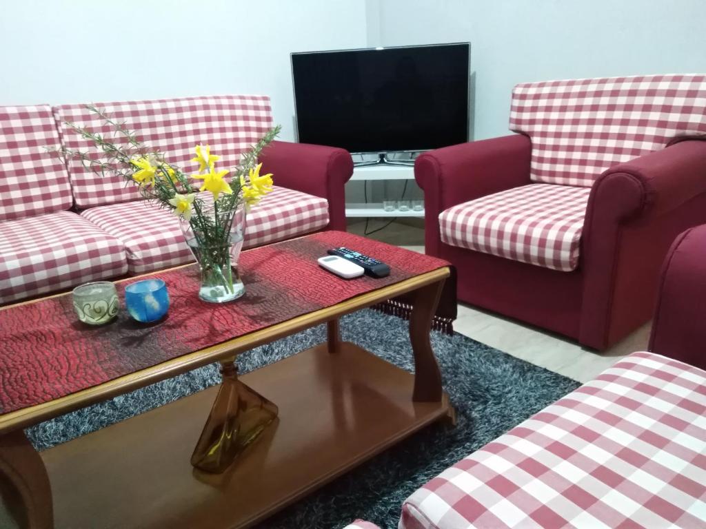 a living room with two couches and a table with flowers at Panos House - High Luxury Apartment in Tríkala