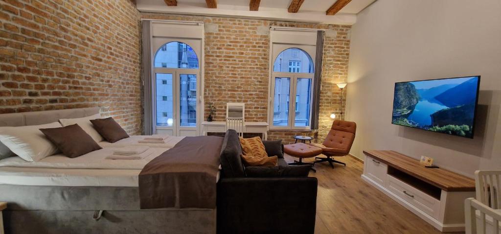 um quarto com uma cama grande e uma parede de tijolos em Old Town Apartments Rajiceva 3 em Belgrado