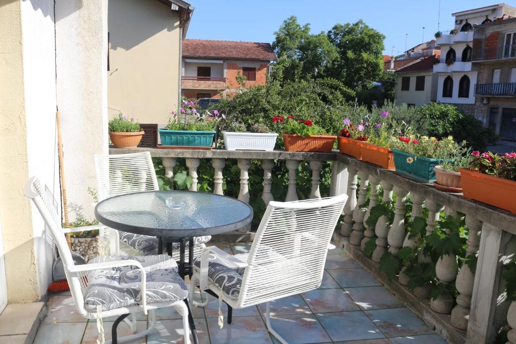 a table and chairs on a balcony with flowers at Apartman Zaton in Zaton