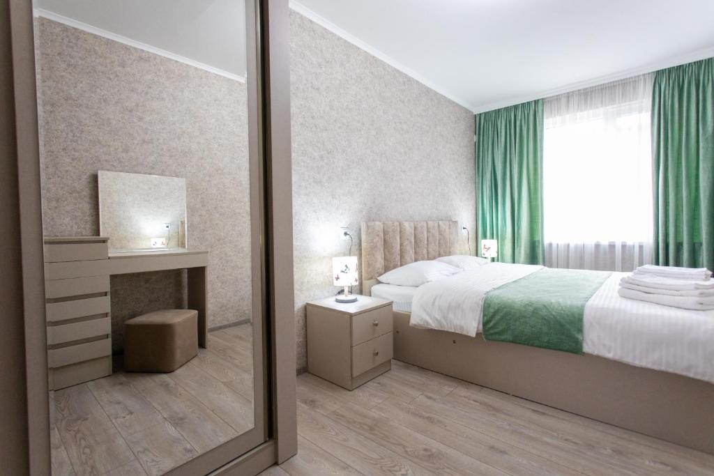 een slaapkamer met een bed en een spiegel bij Ninia's Apartment in Koetaisi