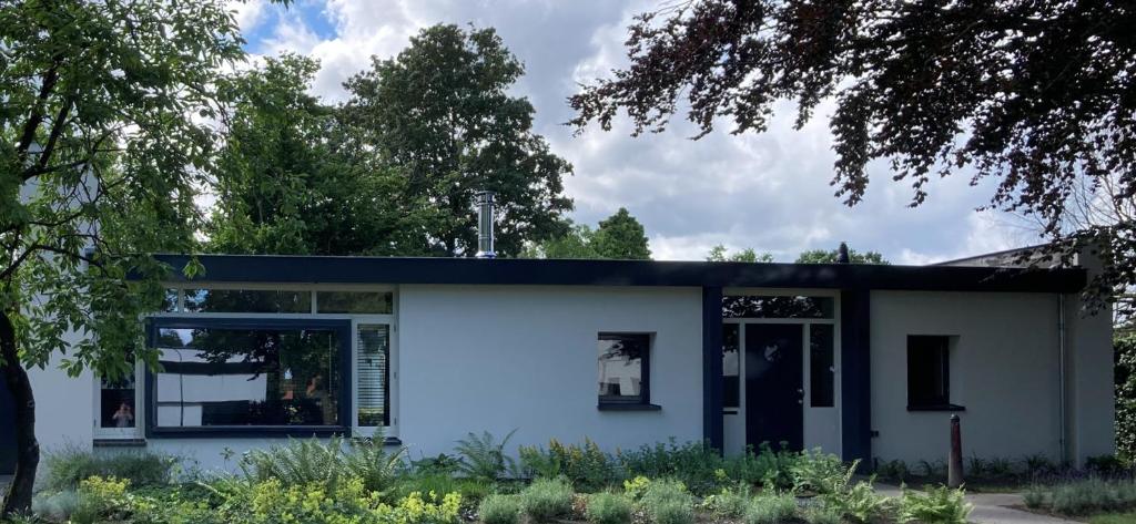 una casa blanca con techo negro en B & B De Rode Beuk, en Hilvarenbeek