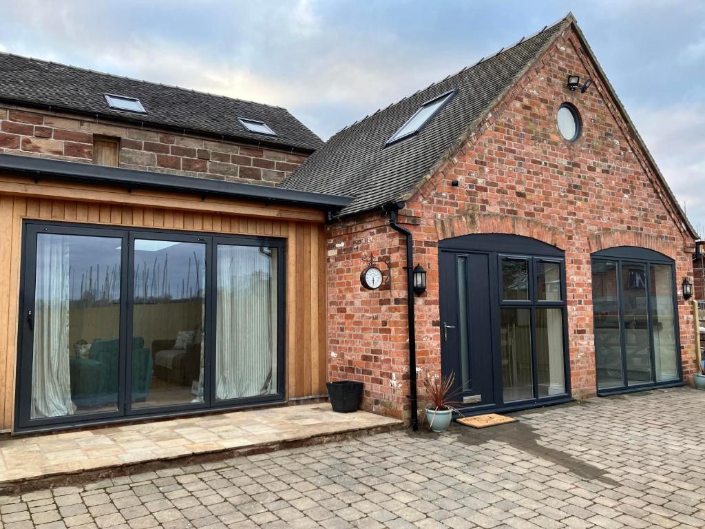 an extension to a brick house with sliding glass doors at Honeyberry Cottage -PART OF ALTON COTTAGES in Alton