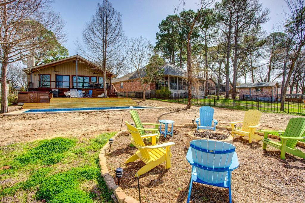 een tuin met kleurrijke stoelen en een huis bij Cedar Creek Lakefront Vacation Rental with Pool in Gun Barrel City