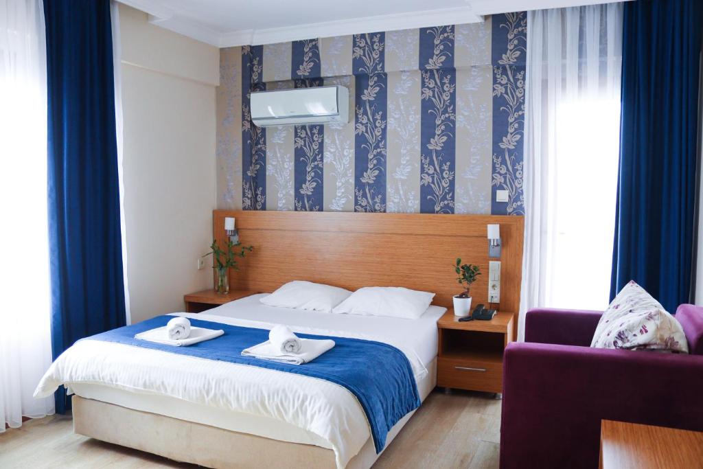 a hotel room with a bed with two towels on it at Siriusmi Hotel in Çeşme