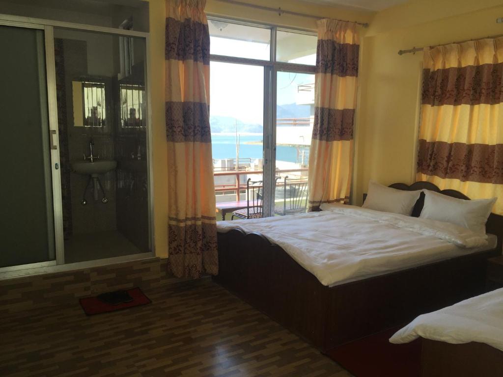 una camera da letto con un letto con vista sull'oceano di Hello Inn Guest House & Apartment a Pokhara