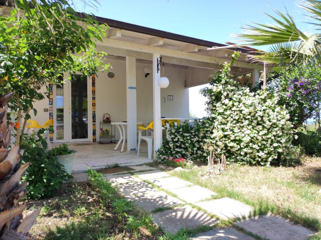 une maison avec terrasse couverte et fleurs dans la cour dans l'établissement Casette Santini B&B, à Casalbordino
